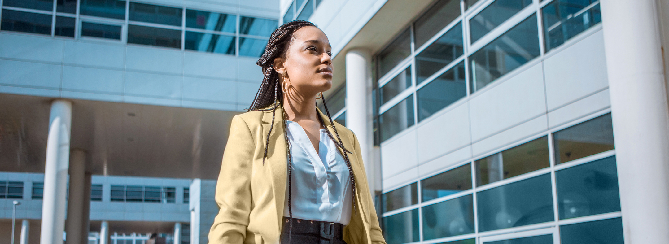 woman in beige blazer walking confidently