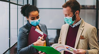 Two work colleagues looking over materials
