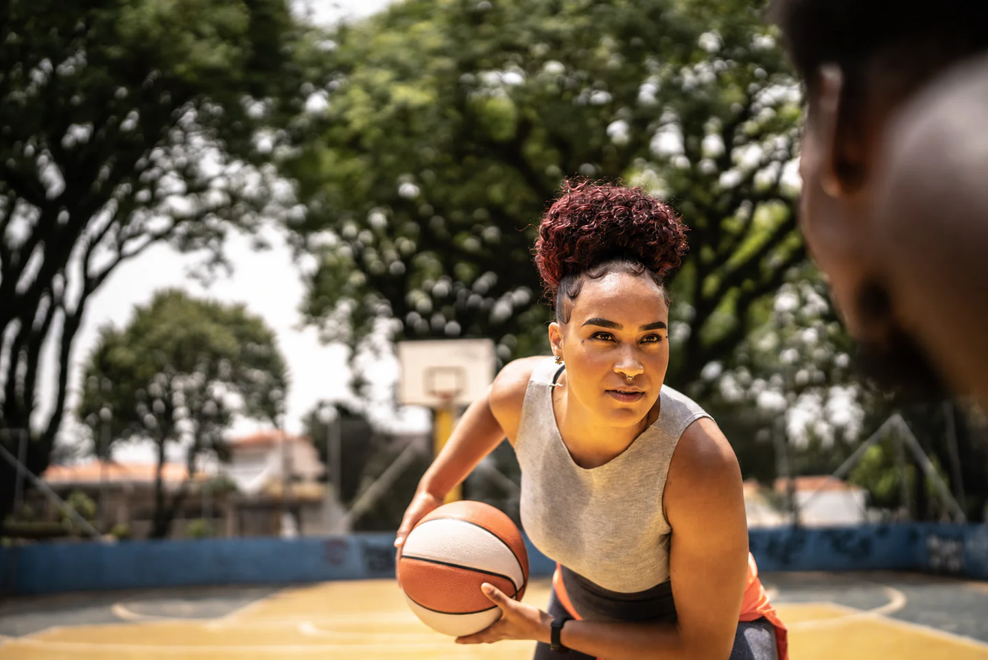 Portrayal of a woman playing basketball on an outdoor court