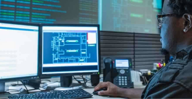 man looking at a computer with two monitors