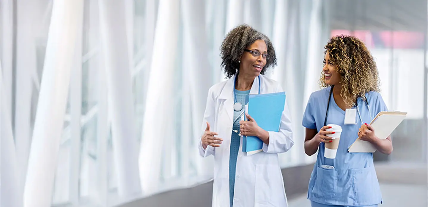 two nurses talking in a hallway