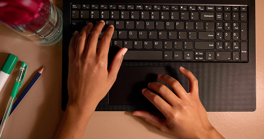 typing on a black laptop keyword