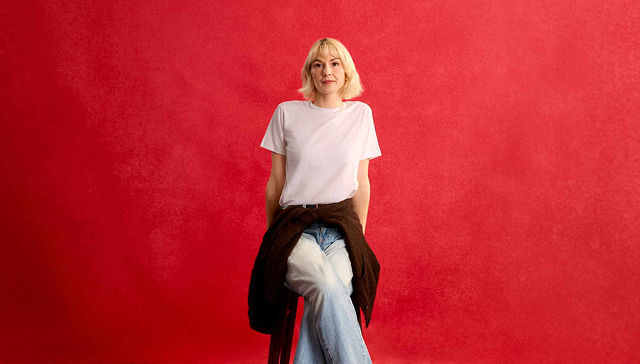woman in white shirt sitting on a stool
