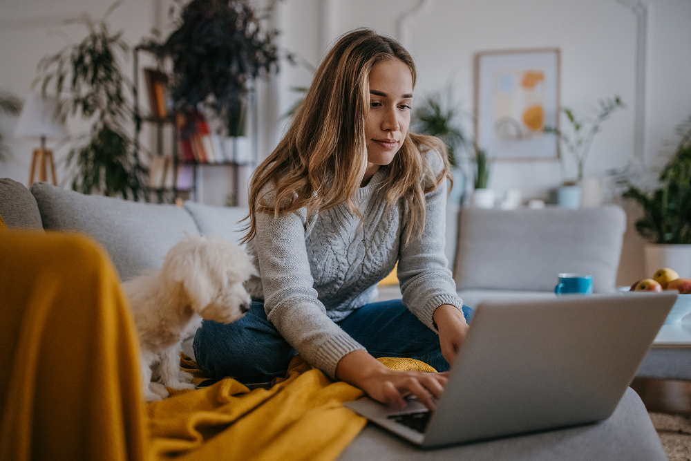 Portrayal of Capella University student on a laptop in her home with her dog.