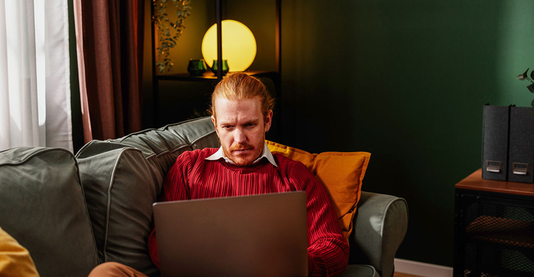 Portrayal of a Capella student studying at home on a sofa