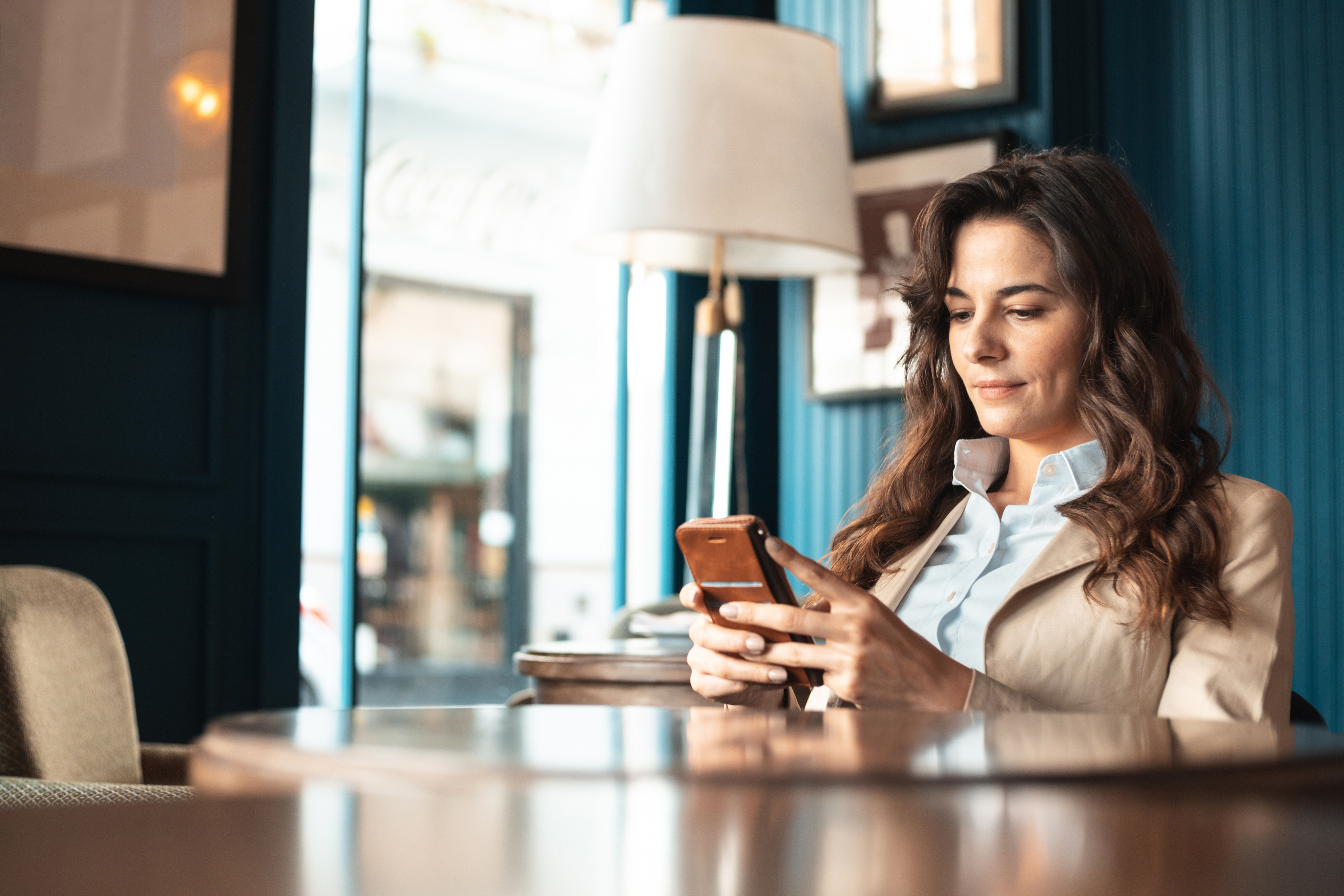 Portrayal of a Capella University online MBA student in an office using her cell phone
