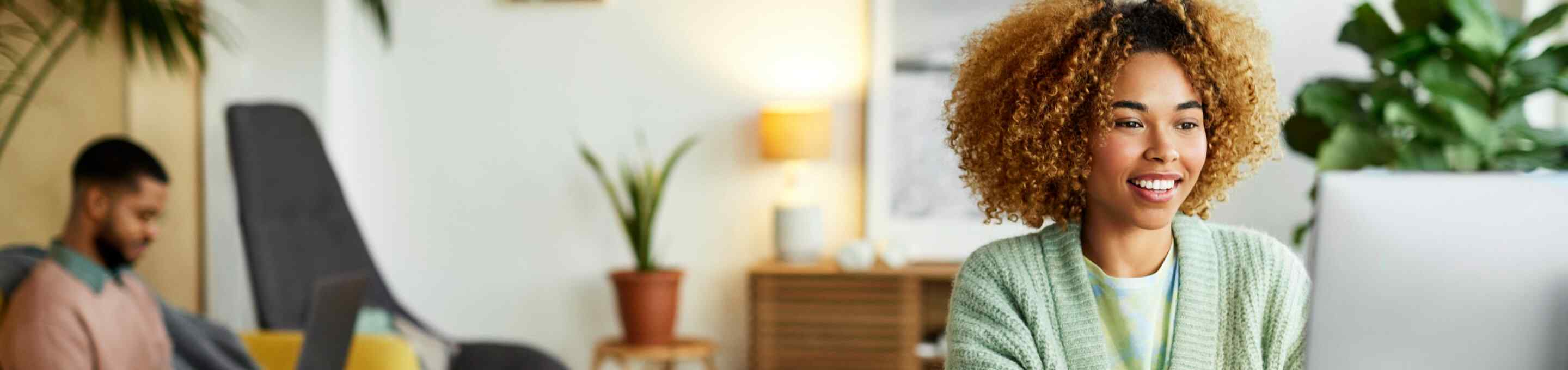 woman in a mint green sweater using a computer 