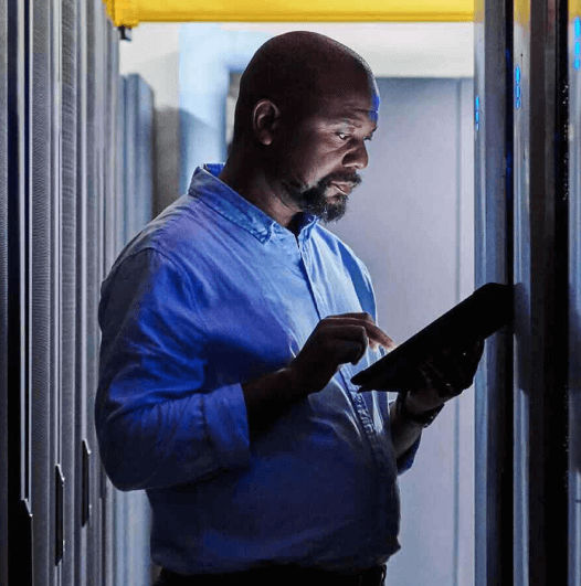 man looking at tablet inside data center