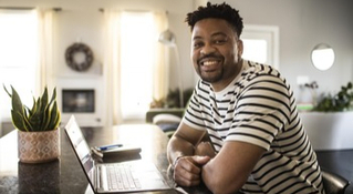 man smiling with laptop open